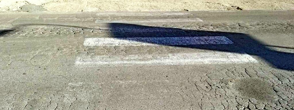Tombini e strisce pedonali sbiadite: ma l'asfalto non è certo messo meglio...