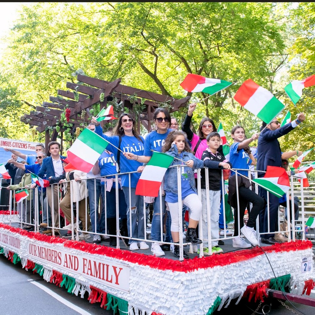 Orgogliosamente sul carro della sfilata nel Columbus Day le famiglie italiane si presentano con maglia azzurra e tricolore